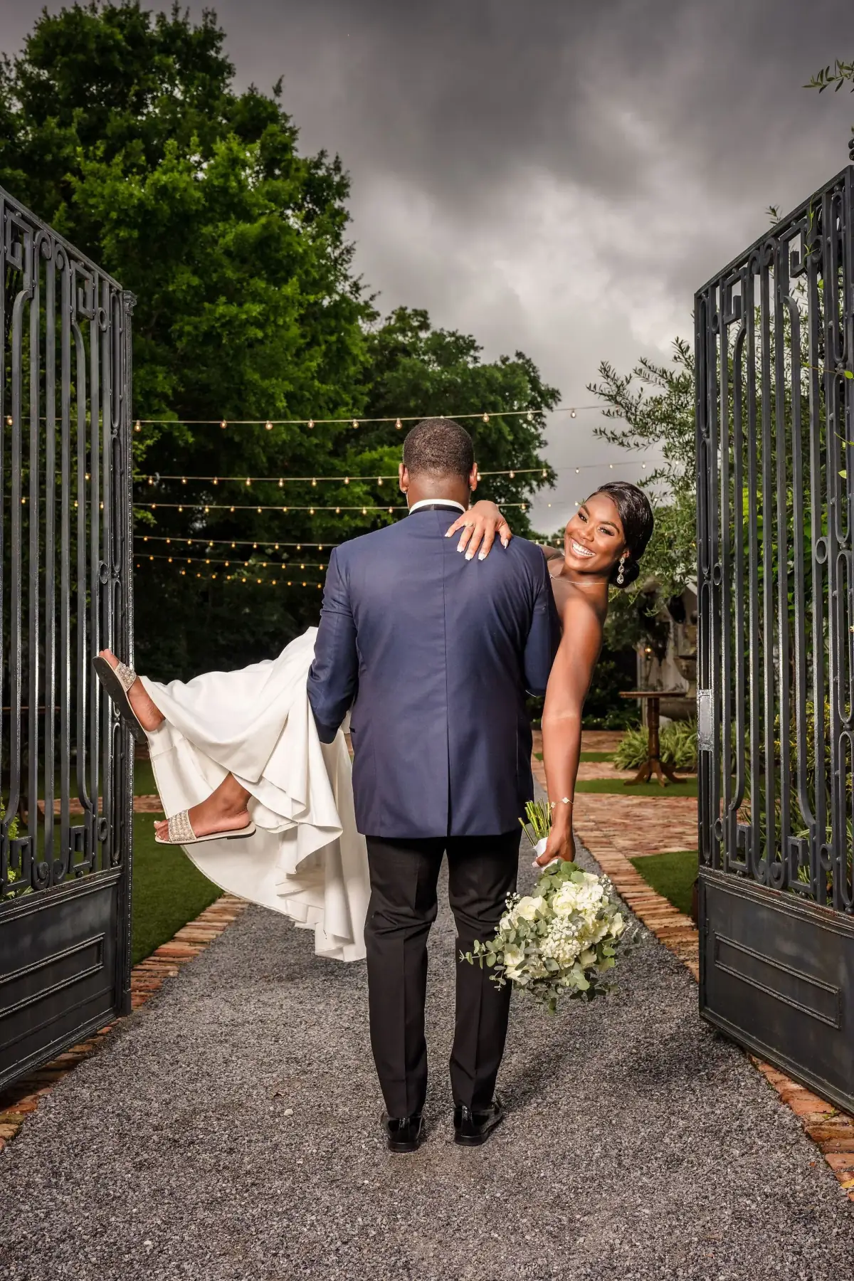 Groom and bride at the gate, train trailing