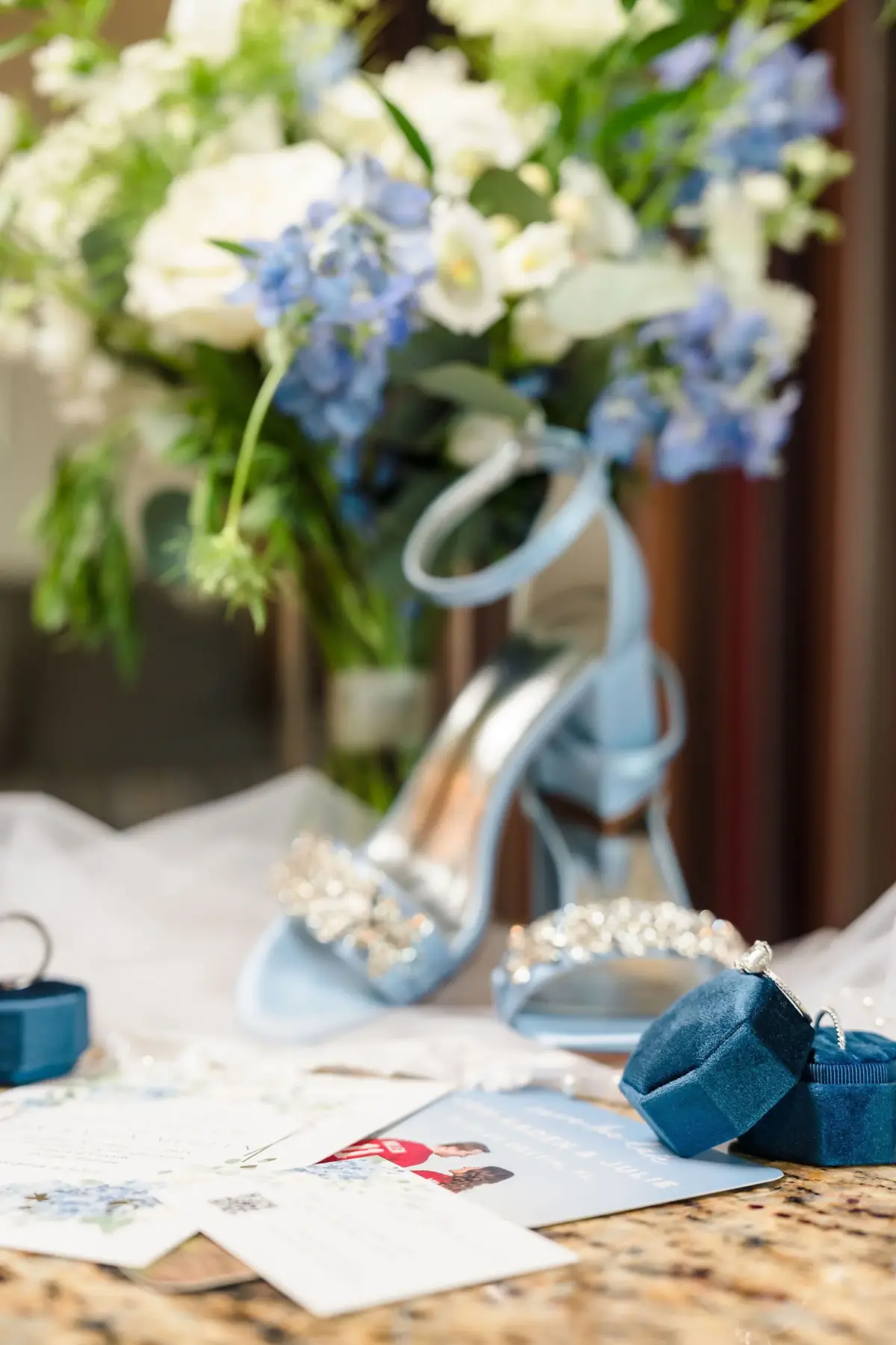Blue bridal heels with the bouquet and invitations