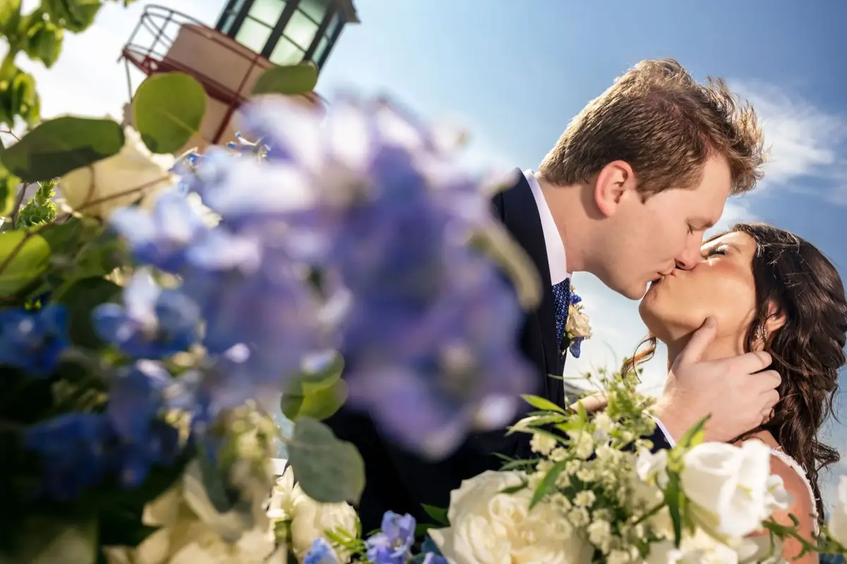A tender kiss against a wall of violet flowers