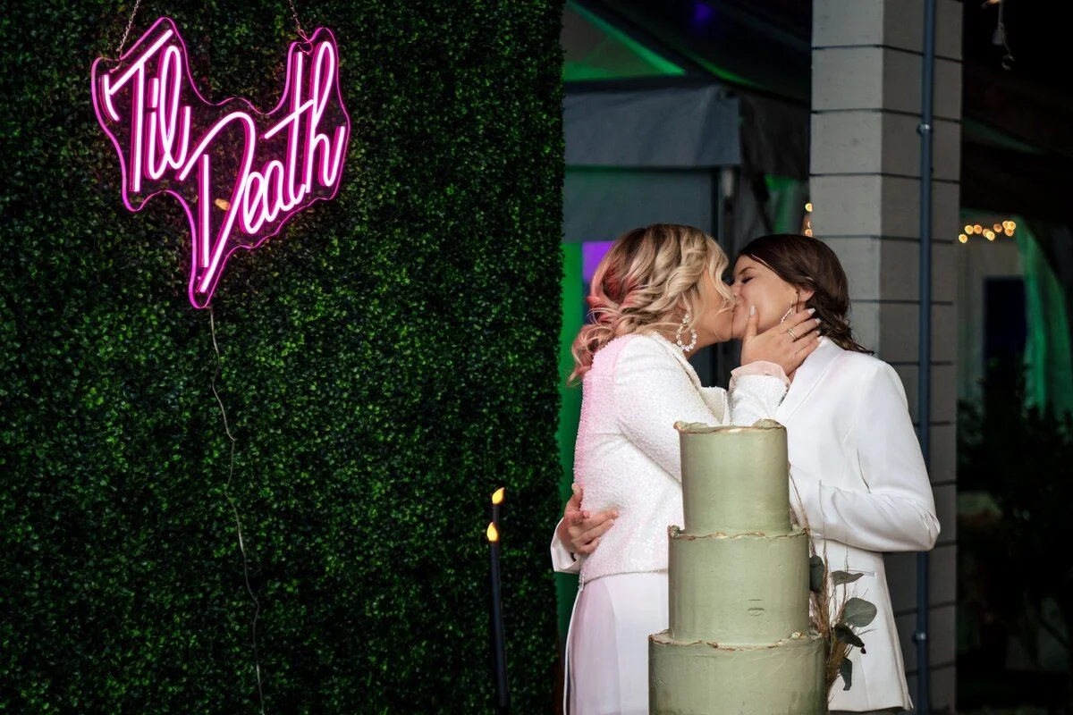 Couple framed by a glowing pink neon sign