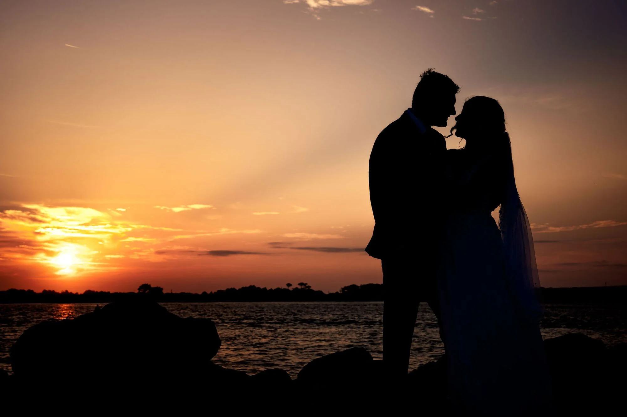 Silhouette of a kiss against an amber sunset