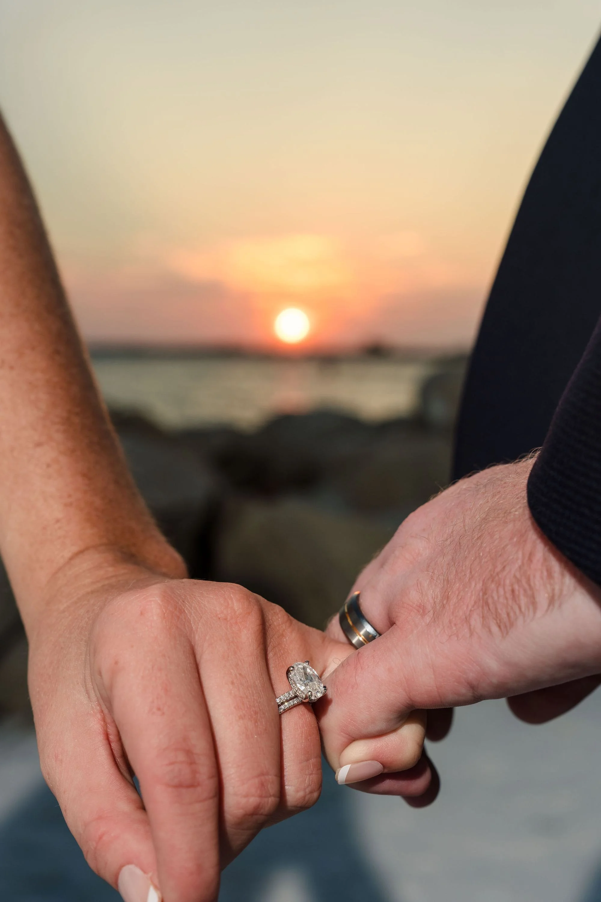 Clasped hands reveal the wedding band, close and quiet