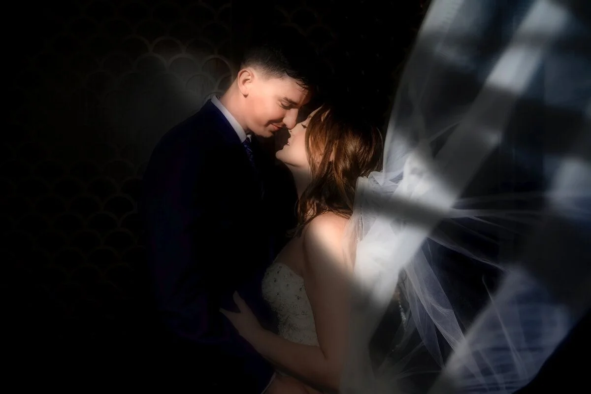 Foreheads together in dramatic streaming window light